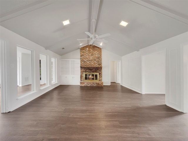 unfurnished living room featuring ceiling fan, a brick fireplace, dark hardwood / wood-style floors, and lofted ceiling with beams