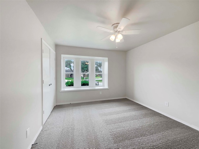 spare room featuring ceiling fan and carpet floors