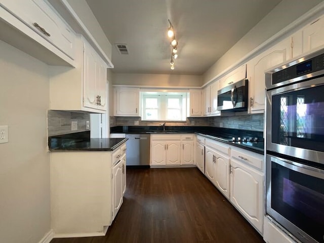 kitchen featuring sink, white cabinetry, appliances with stainless steel finishes, dark hardwood / wood-style floors, and decorative backsplash