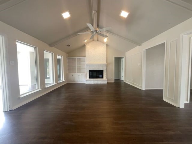 unfurnished living room featuring ceiling fan, vaulted ceiling with beams, built in features, a brick fireplace, and dark hardwood / wood-style flooring