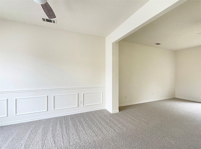 empty room with carpet, a textured ceiling, and ceiling fan