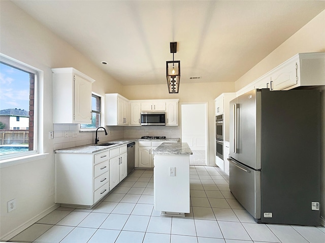 kitchen with white cabinetry, a center island, sink, decorative light fixtures, and appliances with stainless steel finishes