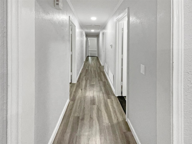 hallway with light hardwood / wood-style floors and crown molding