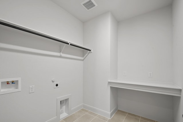 laundry area with electric dryer hookup, hookup for a gas dryer, hookup for a washing machine, and light tile patterned floors