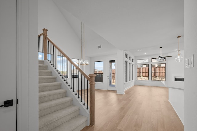 interior space with ceiling fan with notable chandelier and wood-type flooring