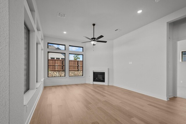 unfurnished living room featuring ceiling fan and light wood-type flooring