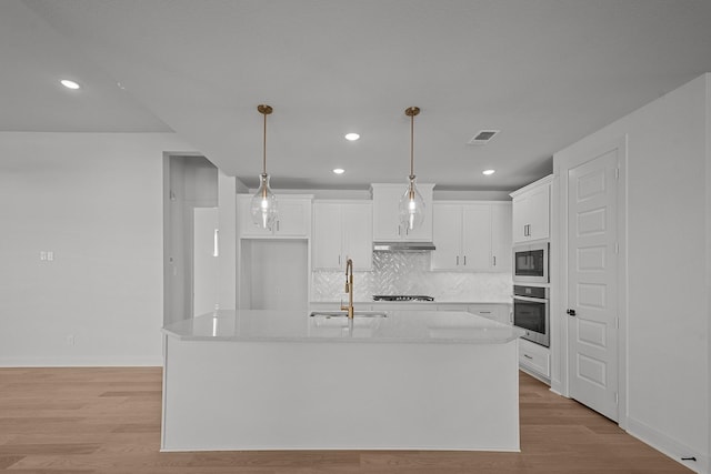 604 Lundy Ln, Mansfield, TX 76063 - kitchen with stainless steel oven, a sink, under cabinet range hood, white cabinetry, and stovetop