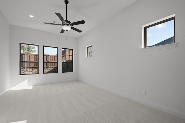 carpeted spare room featuring ceiling fan