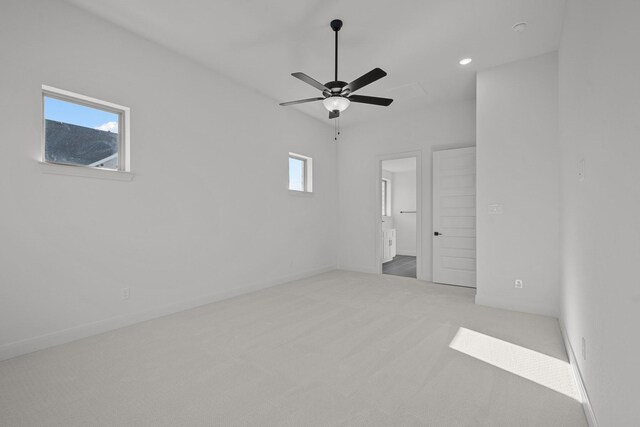 carpeted spare room featuring a wealth of natural light and ceiling fan