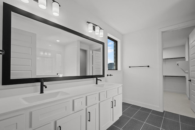 604 Lundy Ln, Mansfield, TX 76063 - bathroom with double vanity, tile patterned floors, a spacious closet, and baseboards