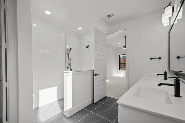 bathroom with tiled shower, vanity, ceiling fan, and tile patterned flooring