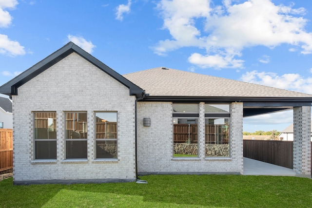 back of property with a yard and a patio area