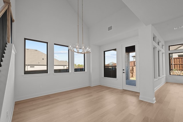 interior space featuring a healthy amount of sunlight, light hardwood / wood-style floors, and high vaulted ceiling