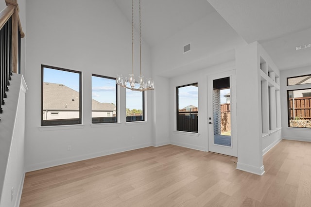 604 Lundy Ln, Mansfield, TX 76063 - unfurnished room with light wood finished floors, a chandelier, baseboards, and a high ceiling