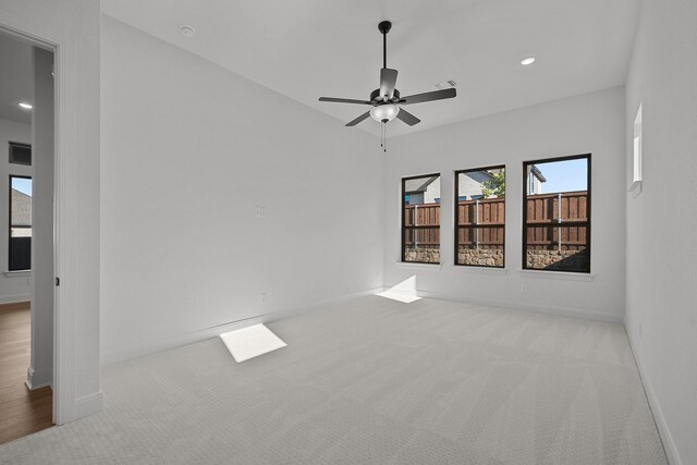 spare room featuring ceiling fan and light colored carpet