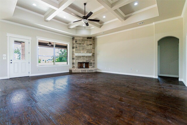 unfurnished living room featuring ceiling fan, a stone fireplace, ornamental molding, and coffered ceiling