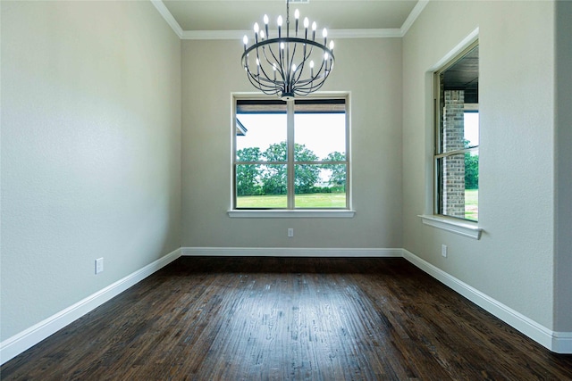 spare room featuring plenty of natural light, dark hardwood / wood-style flooring, ornamental molding, and a chandelier