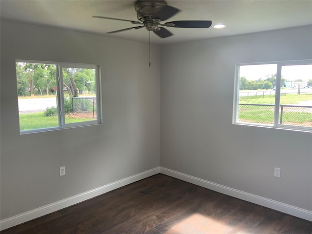 spare room featuring dark hardwood / wood-style flooring, a wealth of natural light, and ceiling fan