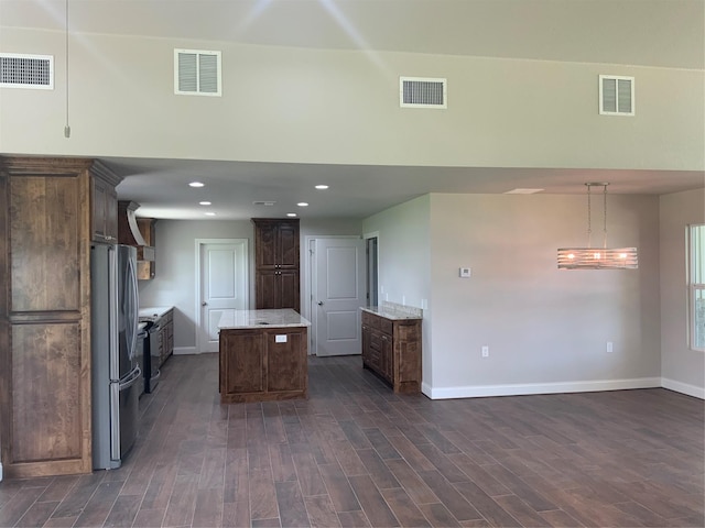 kitchen with decorative light fixtures, a kitchen island, and stainless steel refrigerator