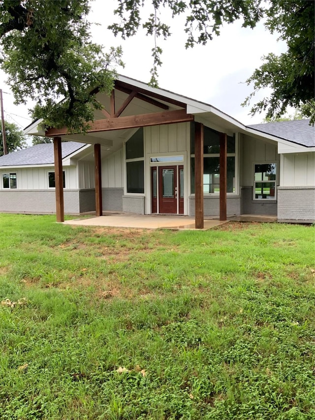 rear view of property featuring a lawn