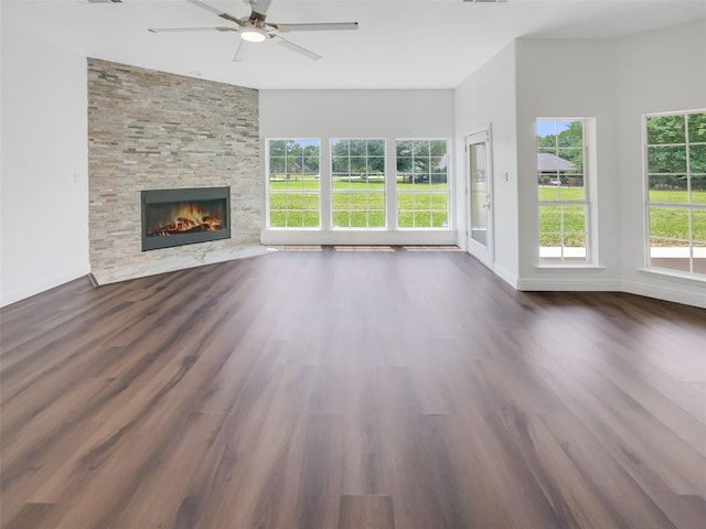 unfurnished living room featuring a fireplace, dark hardwood / wood-style floors, and ceiling fan