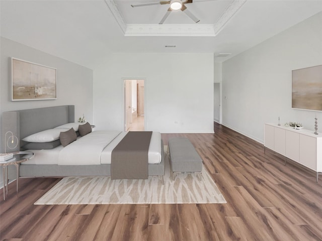 unfurnished bedroom with ceiling fan, wood-type flooring, crown molding, and a tray ceiling