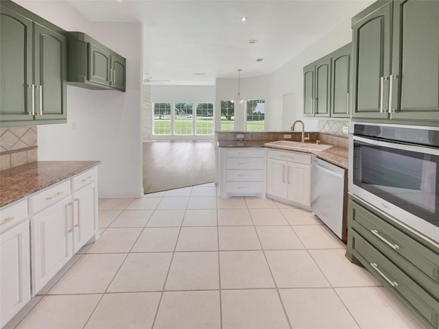 kitchen with white cabinetry, sink, stone countertops, light tile patterned floors, and appliances with stainless steel finishes