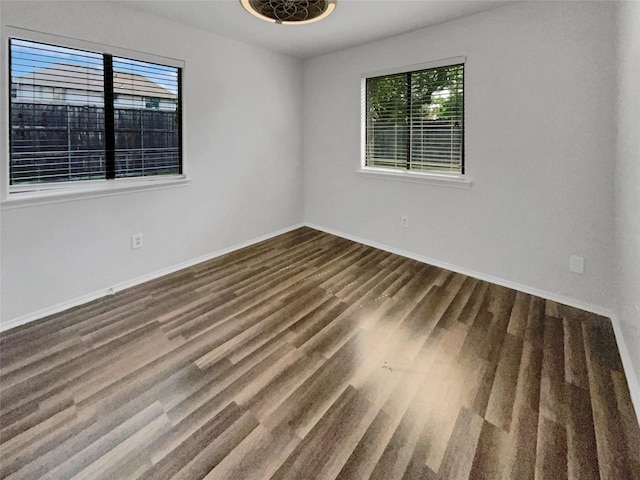 empty room with dark hardwood / wood-style flooring