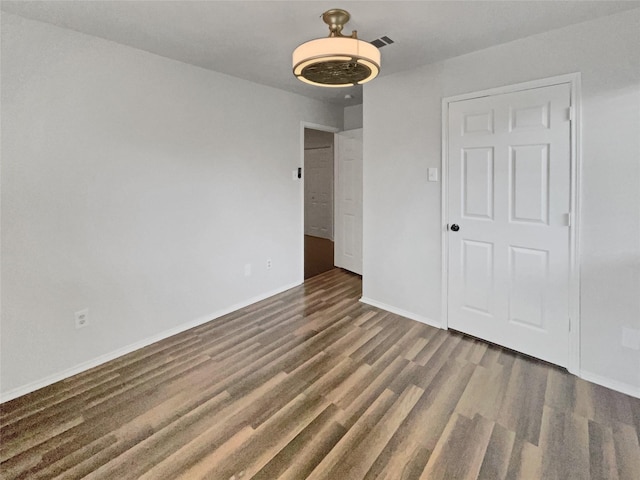 unfurnished bedroom featuring a closet and dark hardwood / wood-style floors