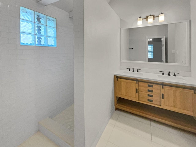 bathroom featuring tile patterned floors, vanity, and a tile shower