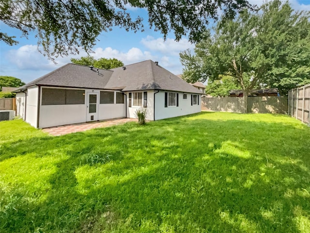 rear view of property with a patio area, central air condition unit, and a yard