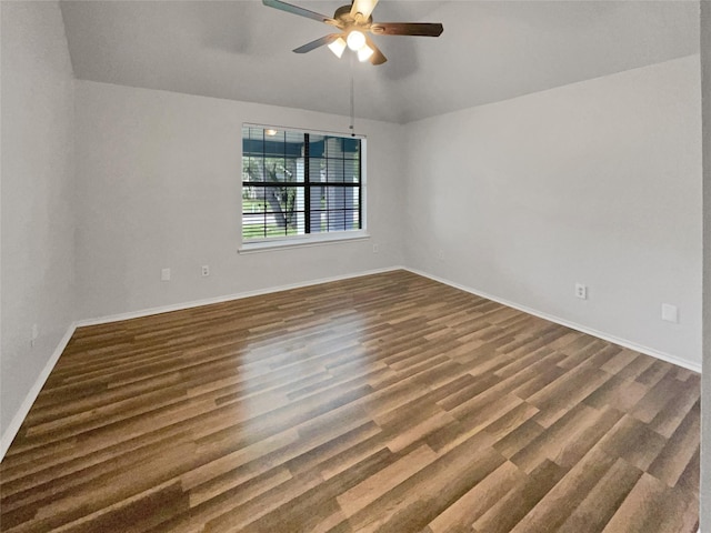 spare room featuring ceiling fan, dark wood-type flooring, and lofted ceiling