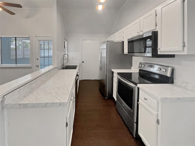 kitchen featuring white cabinets, stainless steel appliances, sink, vaulted ceiling, and ceiling fan