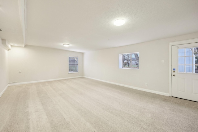 basement with light colored carpet and a textured ceiling