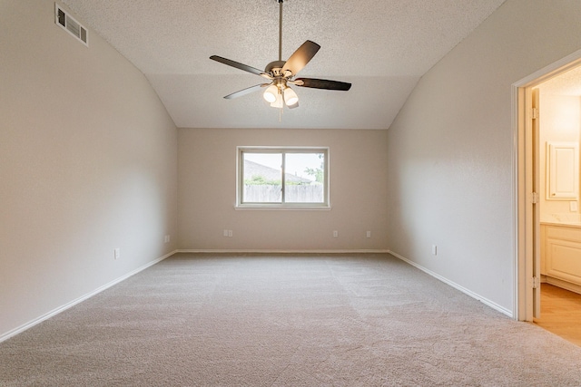 unfurnished room with ceiling fan, a textured ceiling, light carpet, and vaulted ceiling