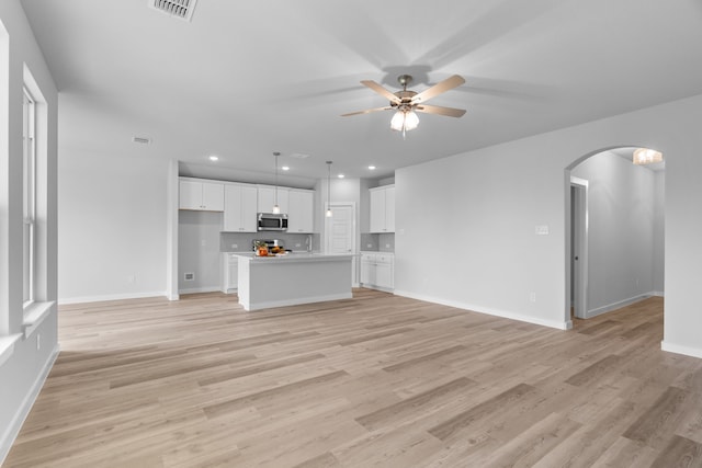 unfurnished living room with light hardwood / wood-style flooring and ceiling fan