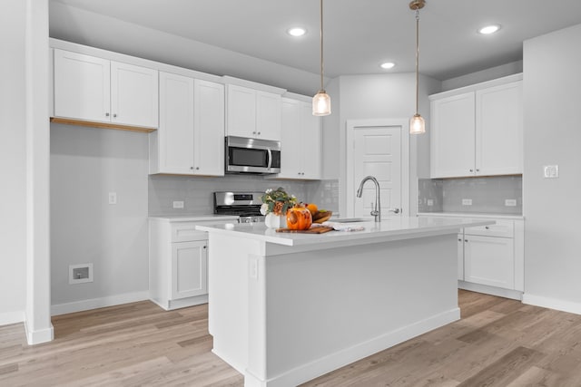 kitchen featuring light hardwood / wood-style floors, a kitchen island with sink, stainless steel appliances, sink, and white cabinets