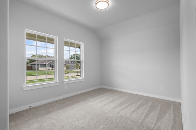 unfurnished room featuring a wealth of natural light, carpet floors, and vaulted ceiling