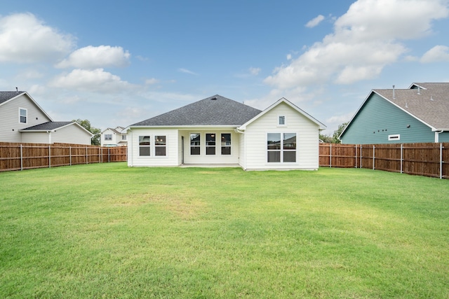 rear view of house featuring a yard