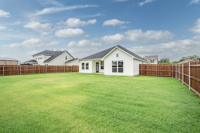 back of house featuring a lawn