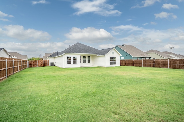 rear view of house featuring a yard