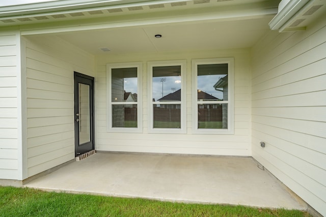 view of exterior entry featuring a patio area