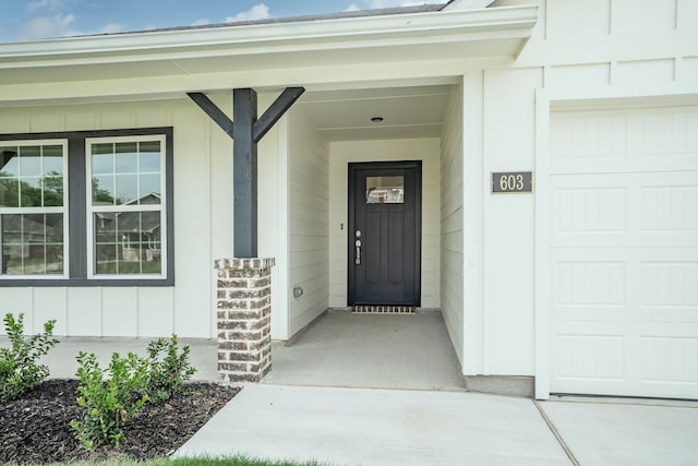 entrance to property with a garage and a porch