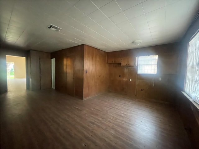 empty room with wooden walls and dark hardwood / wood-style floors