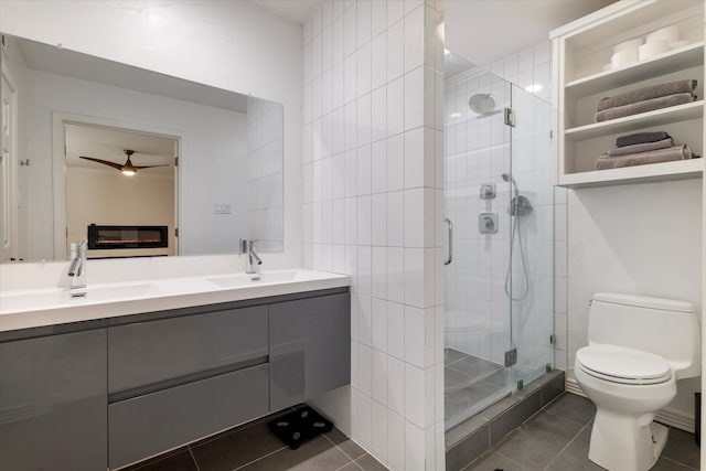 bathroom featuring vanity, tile patterned floors, ceiling fan, toilet, and a shower with shower door