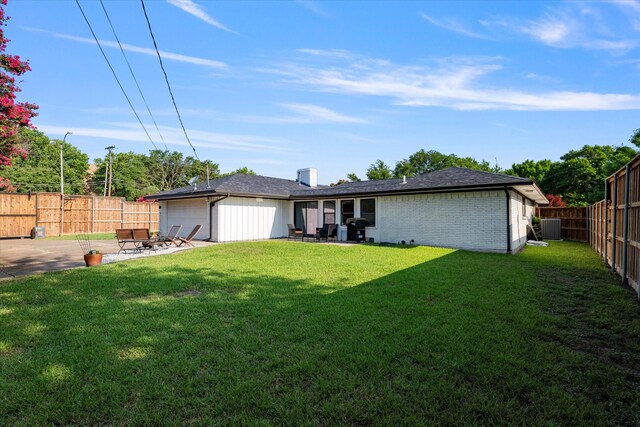 exterior space with cooling unit, a garage, a patio area, and a front lawn