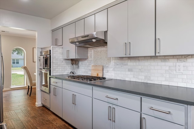 kitchen featuring decorative backsplash, dark wood-type flooring, and stainless steel appliances