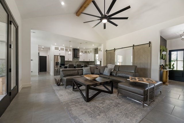 living room with tile flooring, beamed ceiling, a barn door, high vaulted ceiling, and ceiling fan