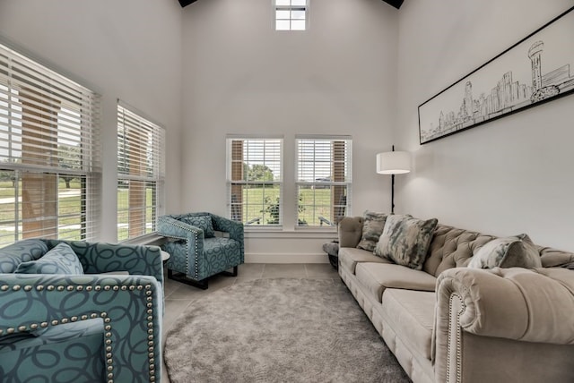 living room featuring tile floors, a wealth of natural light, and a towering ceiling