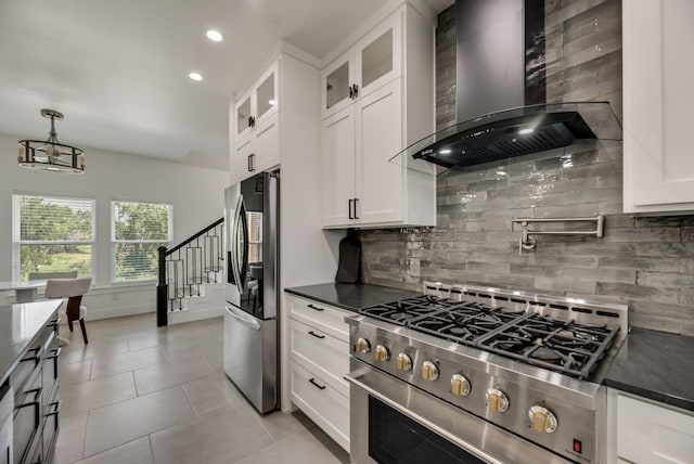 kitchen featuring stainless steel appliances, white cabinets, backsplash, and wall chimney exhaust hood